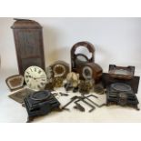 A collection of clock parts and slate gilt footed stands. Clock parts include eight day mantle