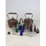 Two copper kettles together with a collection of glass bottles for display W:27cm x H:27cm Kettles