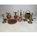 A collection of copper and brass items to include four candlesticks and a candelabra, vases, a