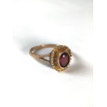 A 9ct gold and garnet dress ring central colete set garnet. 1.9g. Size N