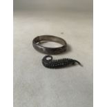 A sterling silver bangle together with a silver marcasite set feather brooch. 1.1oz.