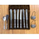 A set of six silver handled butter knives in cutlery wrap, also with unmarked white metal wine