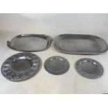 Five white metal decorative plates with various inlaid detail.