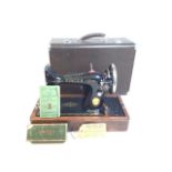 Vintage Singer sewing machine in crocodile effect case with accessories and instruction book.