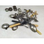 A collection of silver plated items to include napkin holders, cutlery and decorative spoons. Two