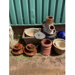 Nine garden pots in varying sizes together with two mini pylons and a sun dial