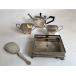 An Art Deco silver plated tea set and a footed tray together with a silver hand mirror with bevelled