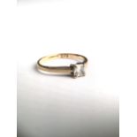 An 18ct gold and CZ ring. Central square cut stone in a four claw setting. 1.5g Size K.