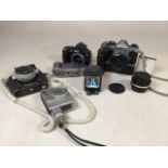 A collection of analog cameras and a bulb. Cameras include NikonOS with a W-Nikkor 1:2,5 F=35mm,