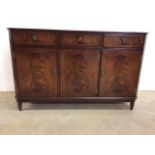 A wood veneered sideboard by Strongbow Furniture. Three drawers above cupboards. Brass handles.