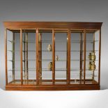 A large, antique mahogany shop display cabinet. An English, Victorian mirror-back cabinet by