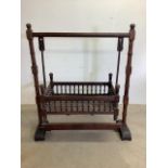 A hard wood swinging cot with turned spindle balustrades W:122cm x D:54cm x H:145cm