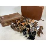 A large quantity of shoe stretchers also with two vintage suitcases.