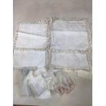 A collection of hand embroidered and lace trimmed cushion covers together with lace trimmed hankies