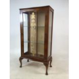 A mid century glazed display cabinet with gilt details, wallpaper back and two glass shelves.