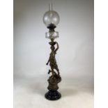 A bronzed figural oil lamp on turned wooden base. H:87cm without glass on top. H:108cm with glass