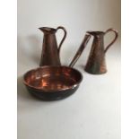 Three copper arts and crafts items to include two pitchers with hand hammered finish, one with
