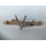 An unmarked precious yellow metal moon and stars bar brooch set with crescent of graduated old cut