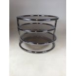 A Maison Jansen style three-tier chrome and smoked glass coffee table with extending round tiers