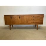 A mid century teak sideboard by Beautility with buckle handles.
