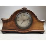 A small French walnut mantle clock with central fan decoration on decorative bun feet. W:25cm x