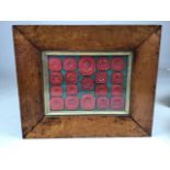 A framed selection of nineteen wax seals in maple frame with gilt mount.W:31cm x H:26cm