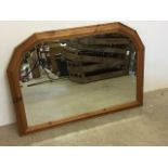 A bevelled mirror in pine frame. W:105cm x H:75cm