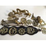 A collection of brass items, horse brasses, elephants and more.