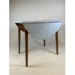 A mid 20th century dinning table with two drop leafs and formica top. Stamped G.F 86 and 12 Oct