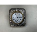 A sterling silver travel clock with repousse decoration in original velvet lined case with easel