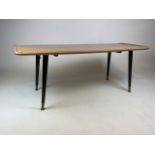 A mid century coffee table with tapered legs and brass feet. W:106cm x D:46cm x H:40cm