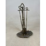 A brass companion set with shovel, tongs and a poker.H:54cm