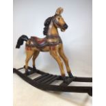 A large carved wooden rocking horse, with original paintwork W:155cm x D:40cm x H:115cm