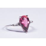 An unmarked precious white metal red (rubelite) tourmaline an diamond ring. Central peare cut