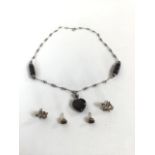 A black coral and white metal necklace and earring set.