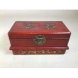 A Chinese red miniature casket with dragon and pheasant on top. Interior lined with Asian paper.