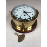 A Smiths Astral brass circular ships clock on walnut circular mount. With key. W:20cm x D:20cm x