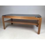 A mid century coffee table with smoked glass top. W:87cm x D:44cm x H:36cm