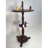 A circular mahogany sewing table with turned spindle reel stands on circular plinth tripod base. W: