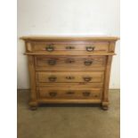 A late 19th early 20th century pine chest of drawers with offset top drawer above three drawers with