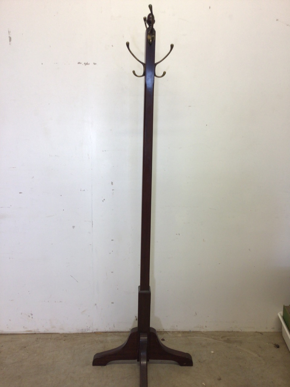 An early 20th century mahogany coat stand with chamfered finish and four brass hooks. H:173cm