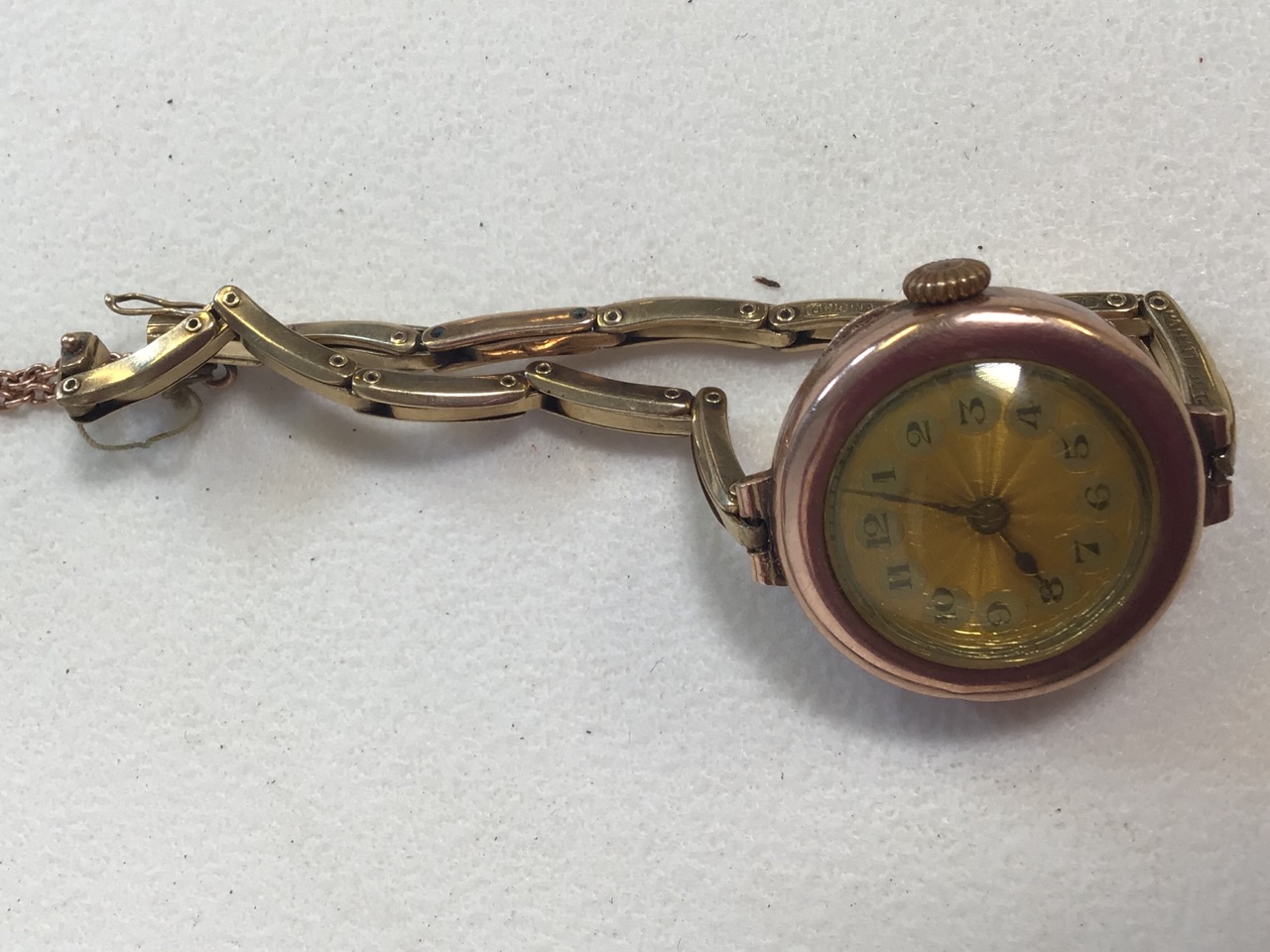 A 9ct ladies cocktail watch on 9ct link chain with enameled tooled face.