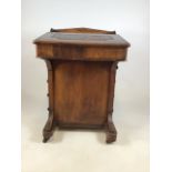 A Victorian inlaid davenport on ceramic castors with leather writing slope to interior desk. With