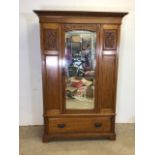 An art nouveau style early 20th century oak wardrobe with bevelled mirror door with interior brass