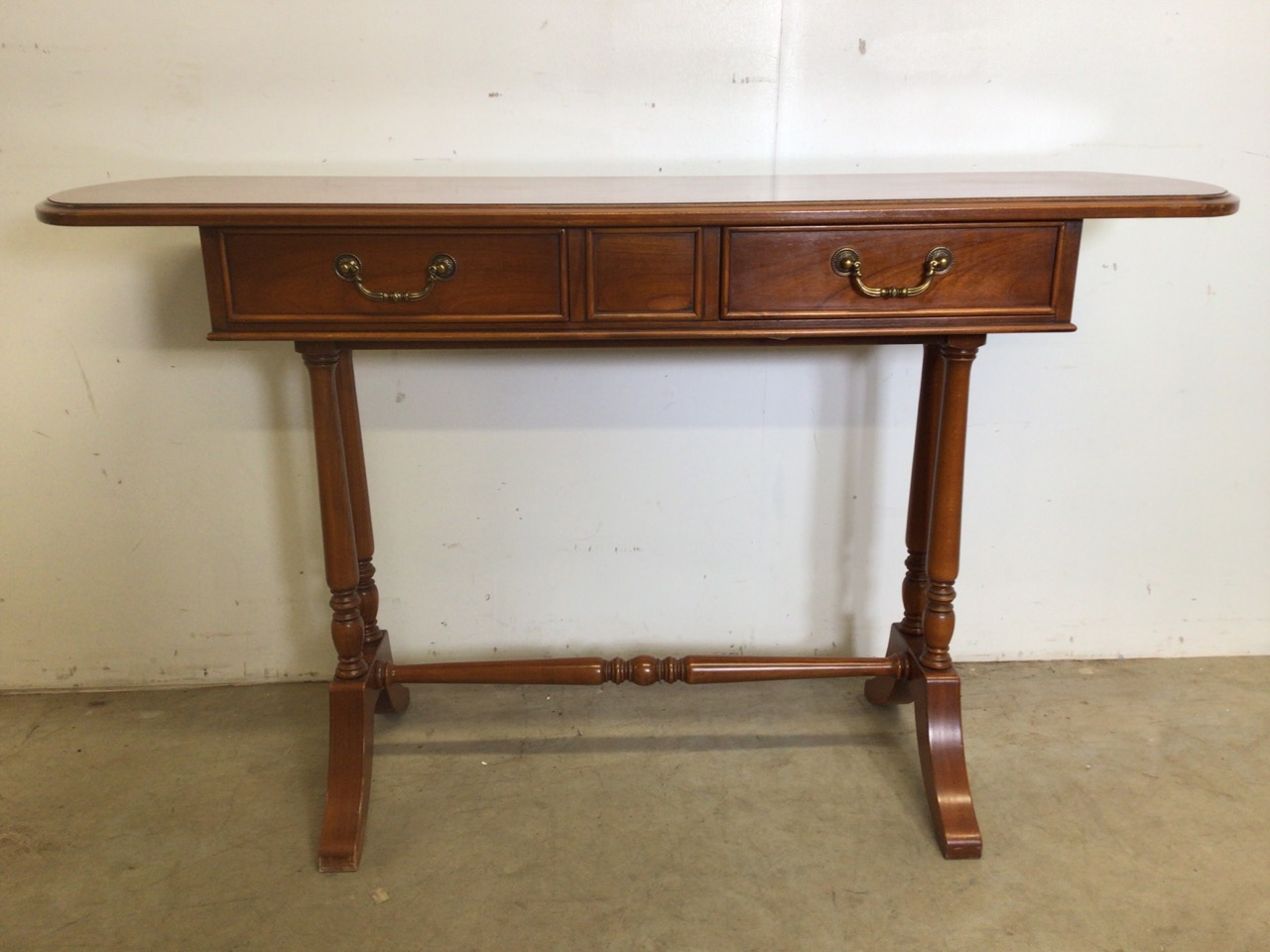 A 20th century French Cherry wood hall table with two drawers with brass handles, stretcher bar to