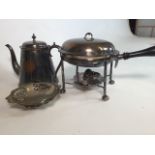 A Silver plated pan on burner stand, kettle and a plated bowl.