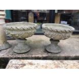 A pair of decorative circular reconstituted stone planters on separate plinths. W:53cm x D:53cm x