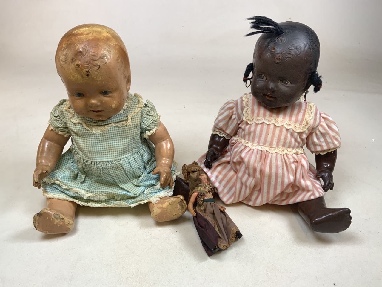 Two mid century composition dolls with a miniature doll together with a china dolls tea set