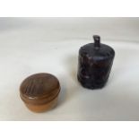 Two Chinese wooden lidded pots. One with marks to base . Dark wood carved with leaves 13cm height