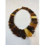 An rough amber/copal necklace with inset insect inclusions. Approx 42cm.